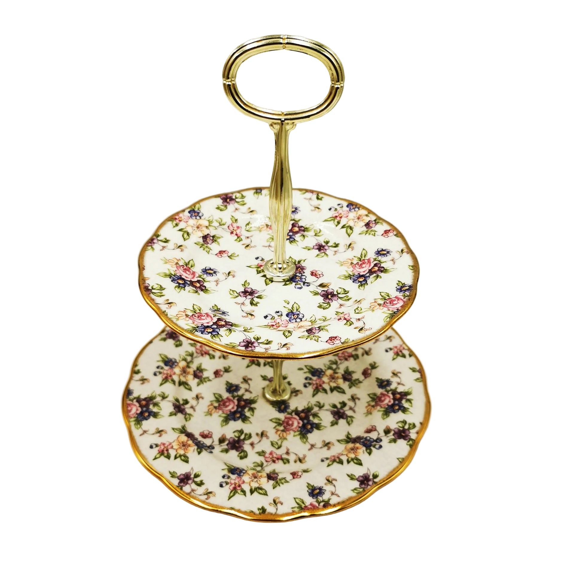 Two-tiered ceramic cake stand with floral pattern and gold trim on a neutral background