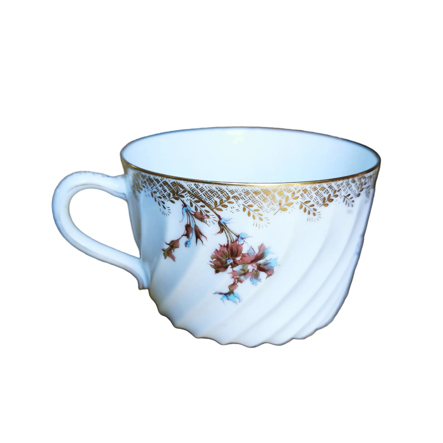 A white ceramic teacup with a gold decorative band and delicate floral illustrations, resting on a rustic wooden table.