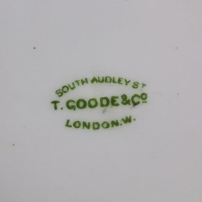 Close-up of the bottom of a white porcelain dish or cup, showing green printed maker's mark text reading 'SOUTH AUDELY ST T. GOODE & Co LONDON' with some brown staining near the rim.