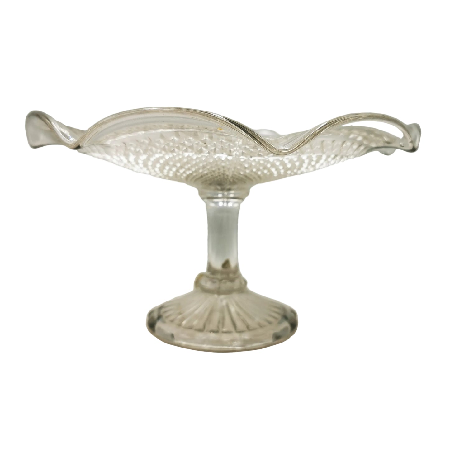 A clear glass pedestal bowl with a textured, diamond-cut pattern and wavy rim, set against a neutral light gray background.