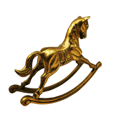 A vintage-style metallic gold rocking horse figurine on a plain light gray background.