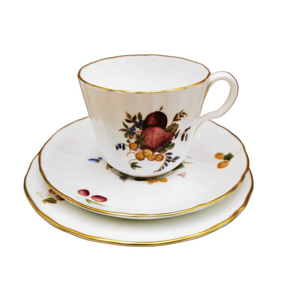 A white porcelain teacup and saucer set with gold trim and a hand-painted fruit motif, displayed on a matching saucer against a brown background.