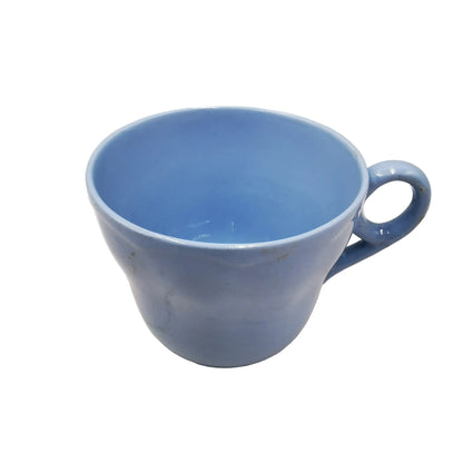 A light blue ceramic coffee mug with a loop handle, photographed on a plain off-white background.