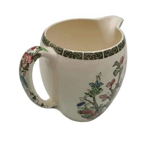 Ceramic pitcher with floral patterns on a plain background