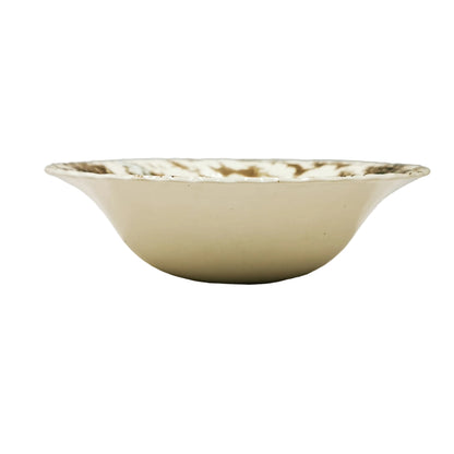 A vintage cream-colored ceramic bowl with a brown floral pattern around the rim, photographed on a neutral light gray background.