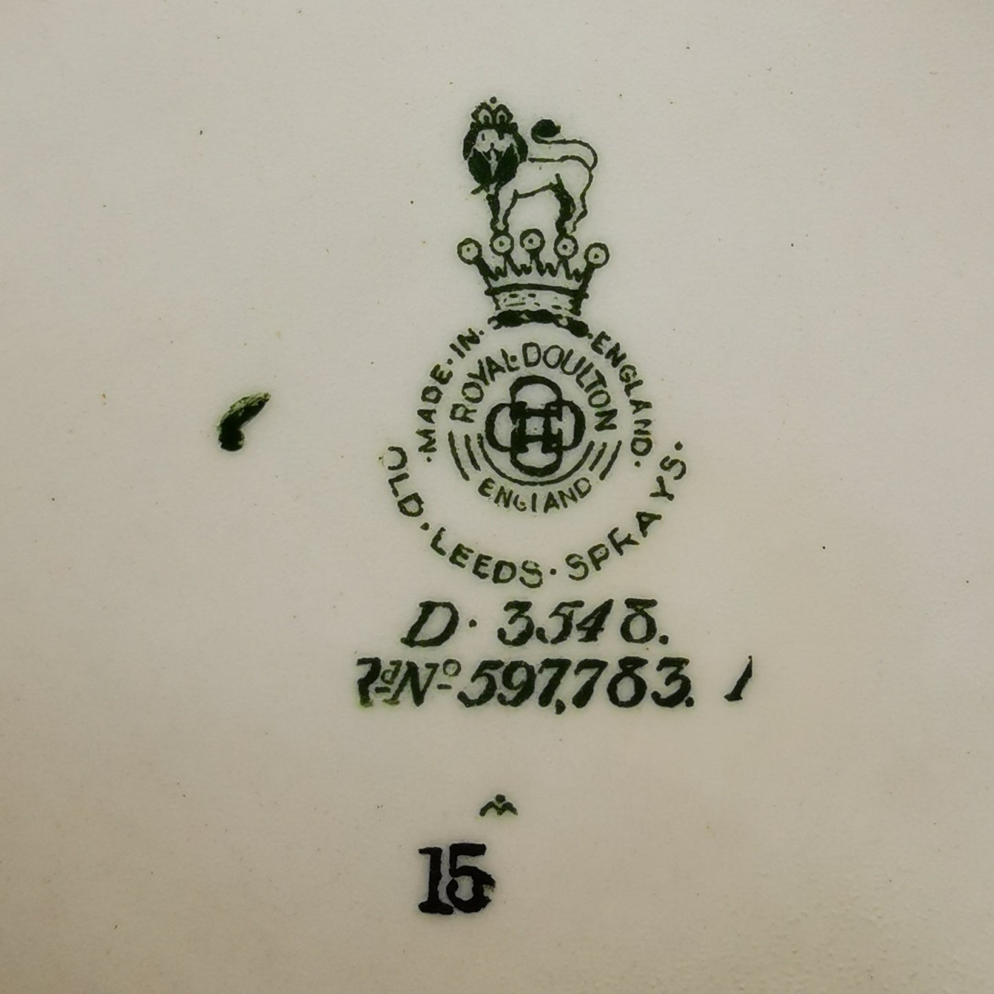 Close-up of a white ceramic surface showing a dark green Royal Doulton England stamp with the brand lion crest, manufacturing details, and the number 15.