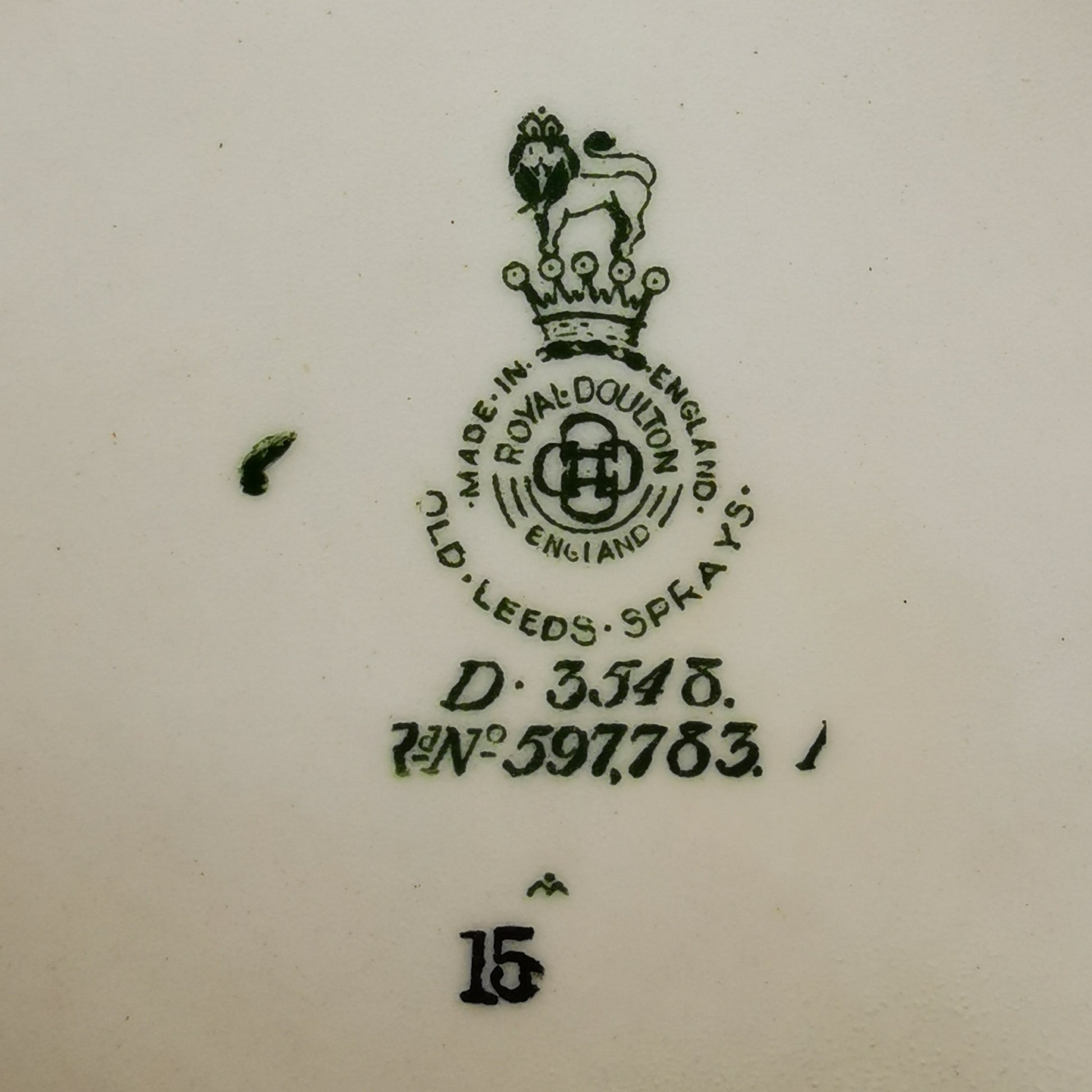 Close-up of a white ceramic surface showing a dark green Royal Doulton England stamp with the brand lion crest, manufacturing details, and the number 15.