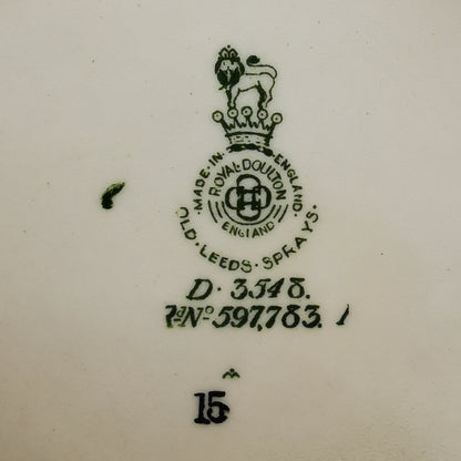 Close-up of a white ceramic surface showing a dark green Royal Doulton England stamp with the brand lion crest, manufacturing details, and the number 15.
