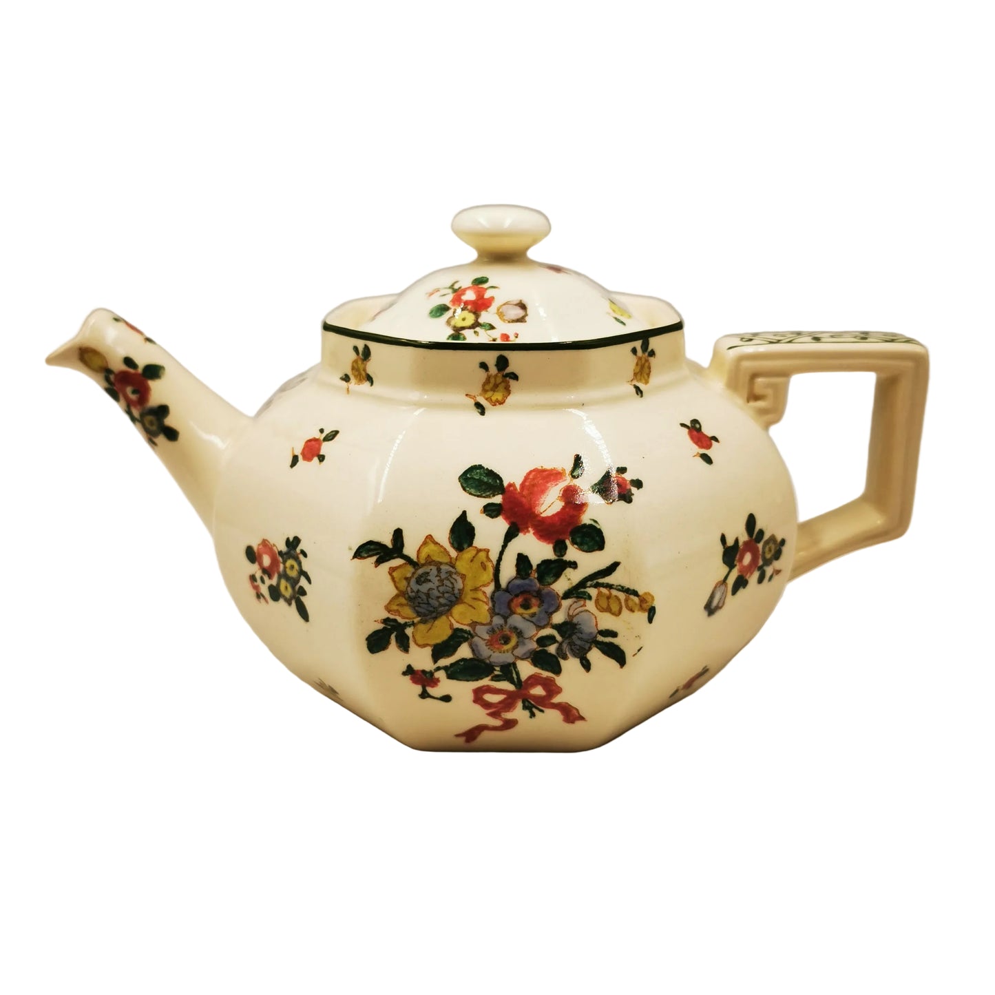 An antique-style ceramic teapot with a cream-colored body, decorated with a colorful floral pattern and a green band around the neck, set against a plain light gray background.
