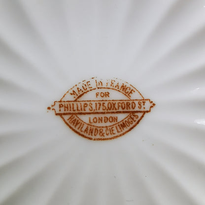 Close-up of the inside bottom of a white fluted ceramic dish, showing a brown stamp that reads 'MADE IN FRANCE FOR PHILLIPS 175 OXFORD SHILLINGTON & CO LONDON'.