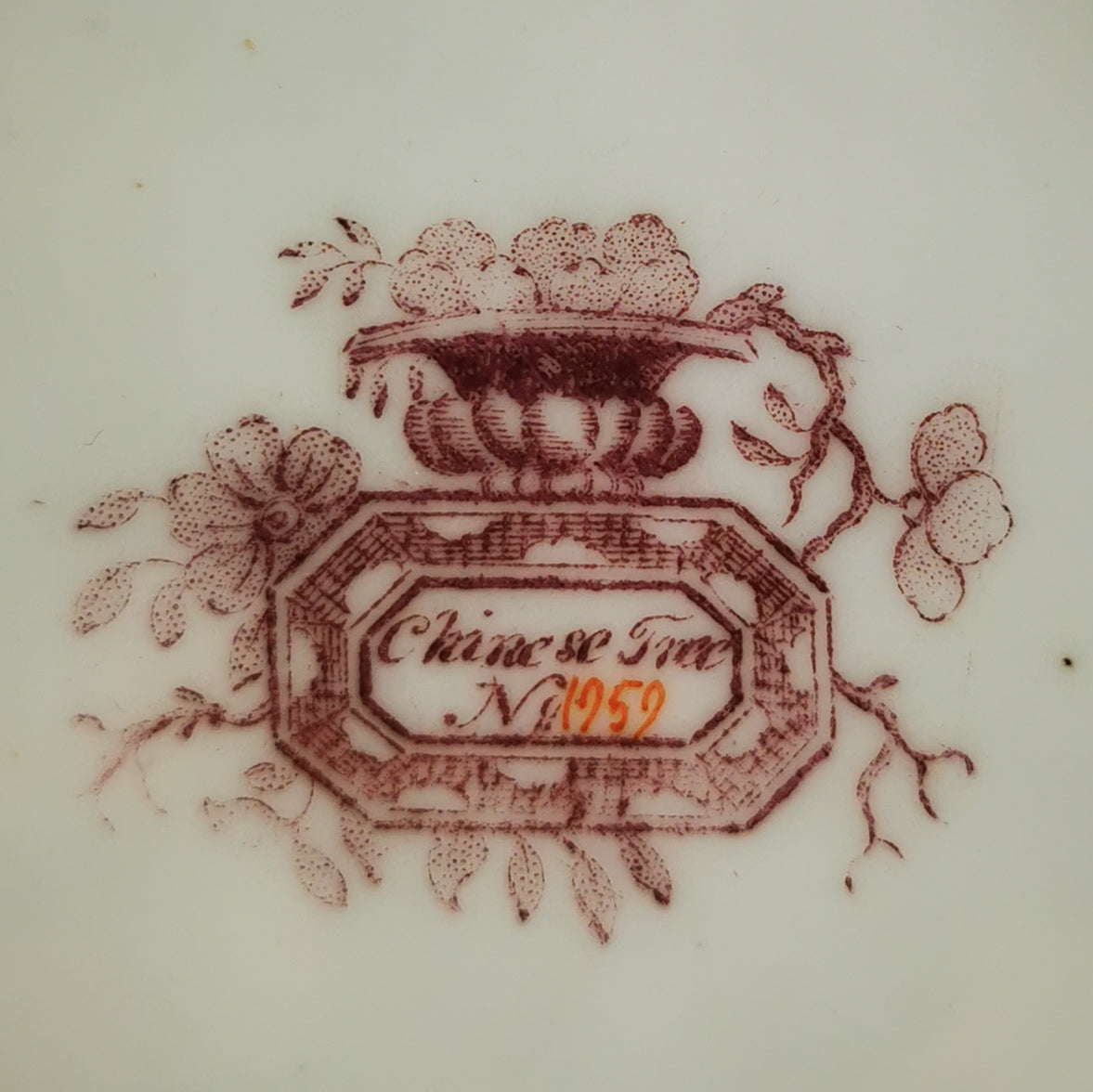Close-up of a white porcelain surface featuring a reddish-brown printed Chinese Tea motif with a central label reading 'Chinese Tea No 1959'.